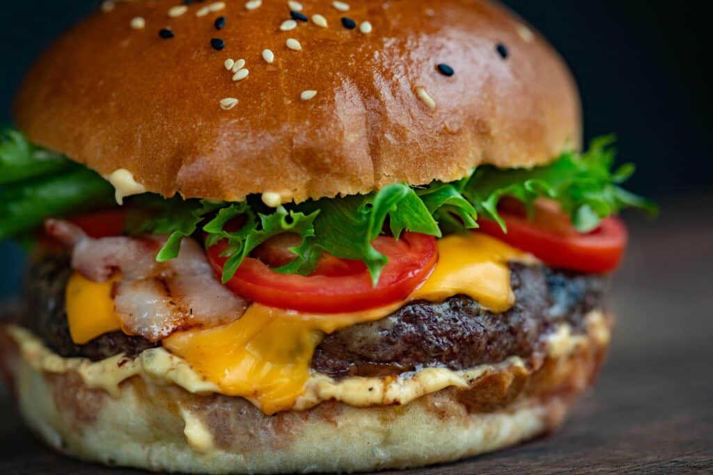 Juicy cheeseburger with bacon, lettuce, tomato, and sesame seed bun.
